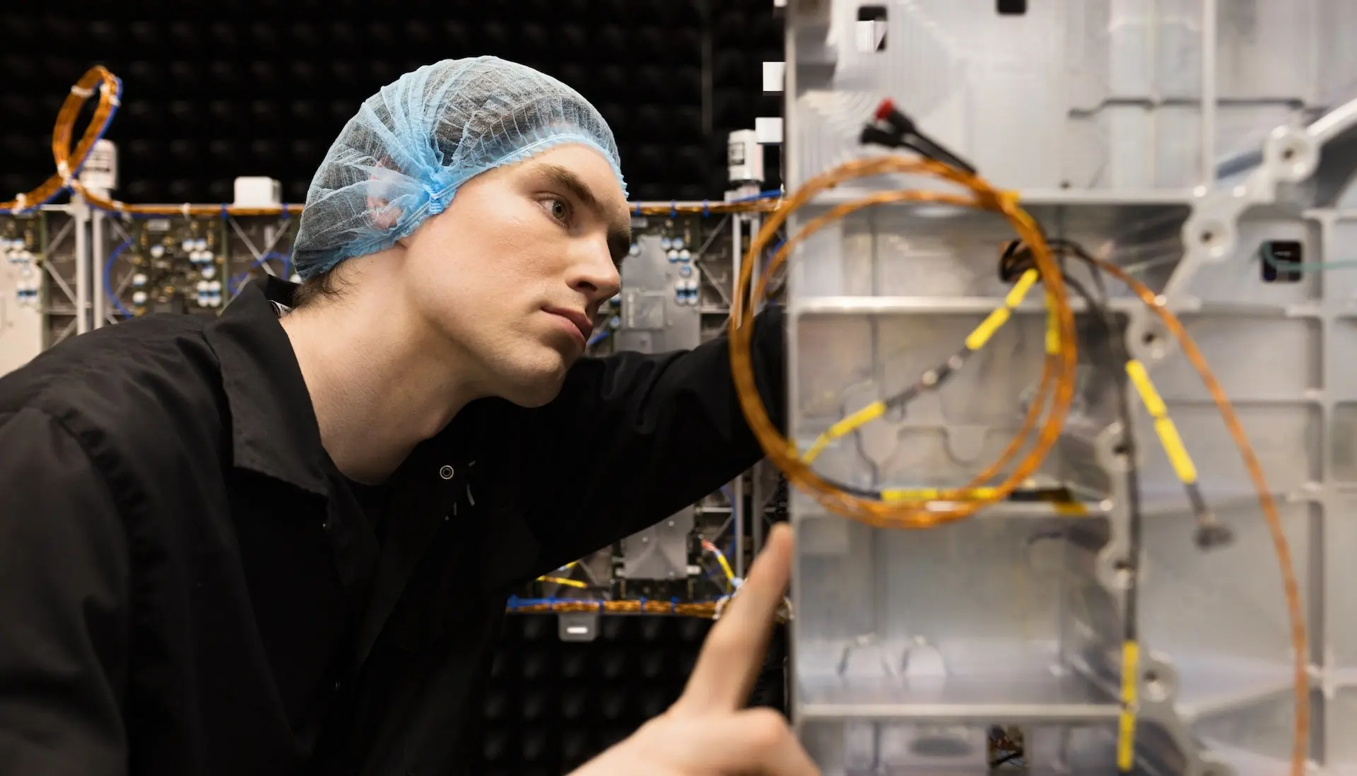 Male ICEYE employee working on satellite